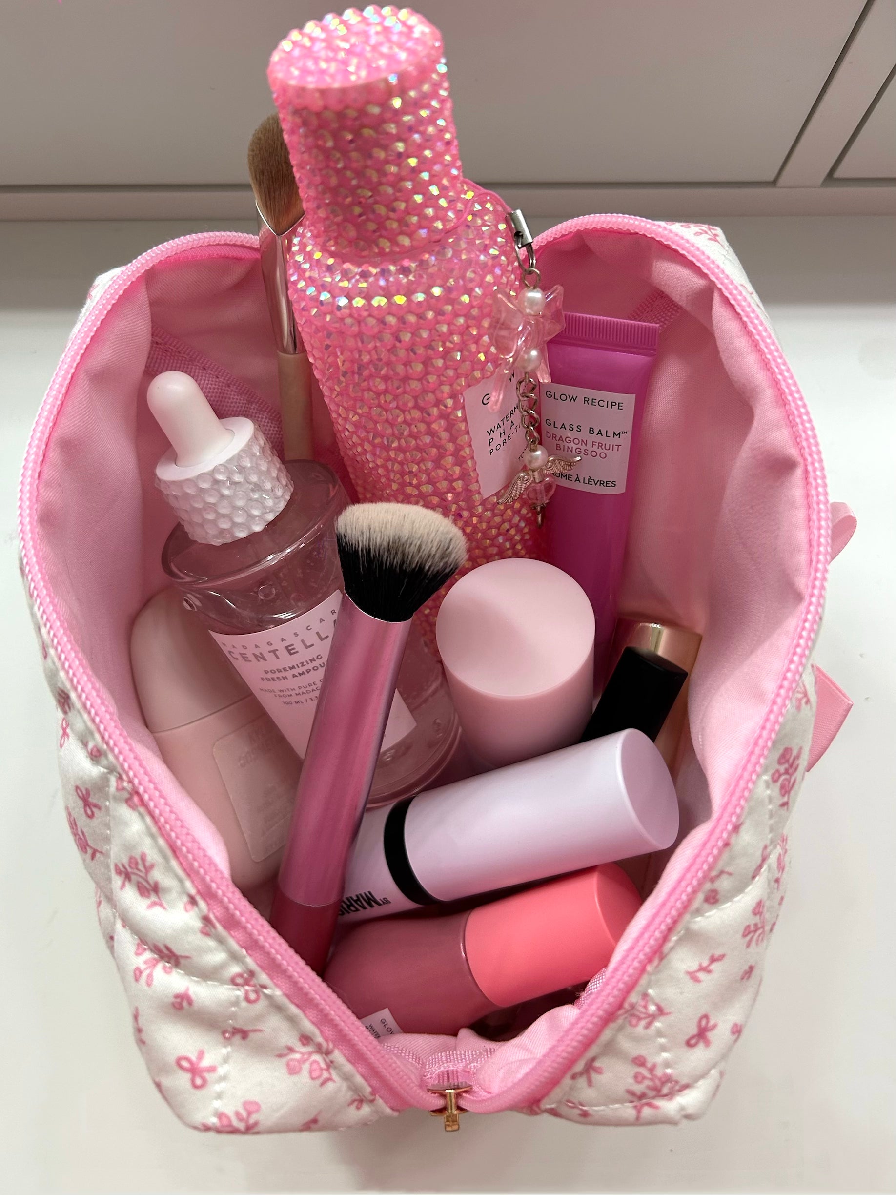 PrettyLittlePink bow makeup bag size reference with items inside